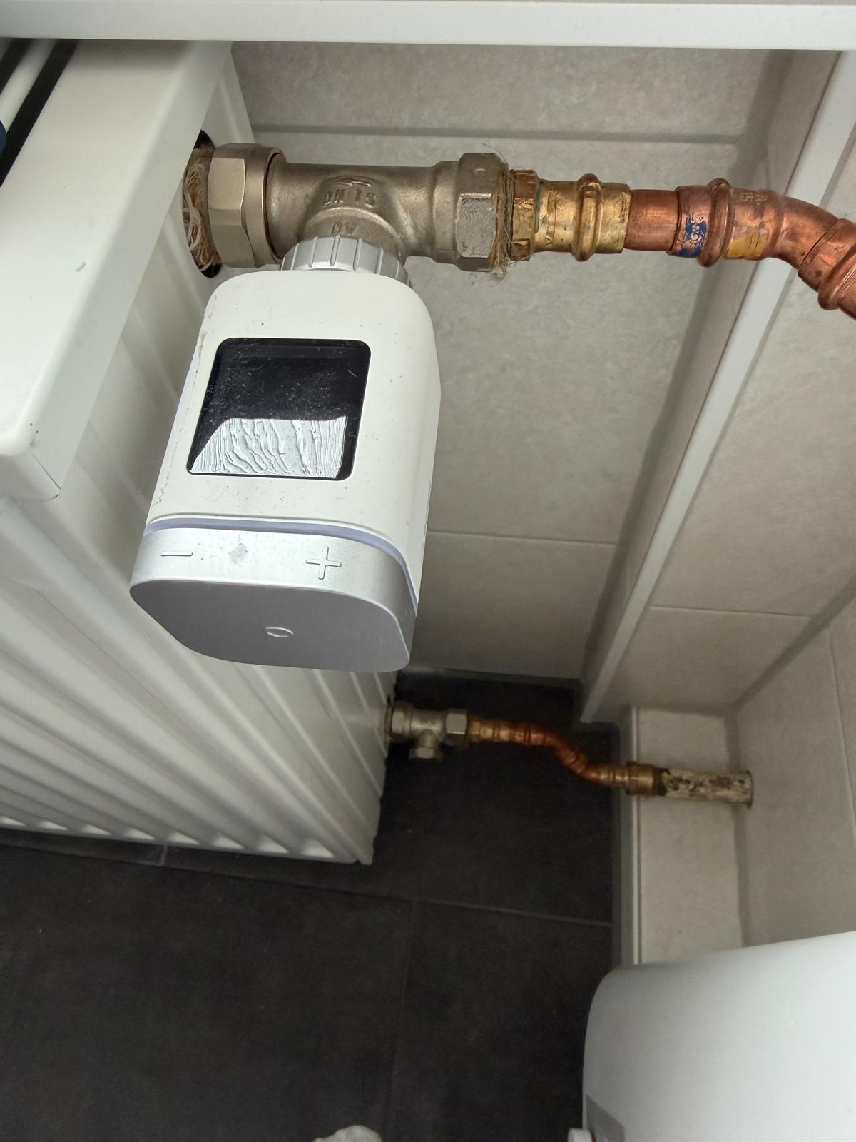 Elektronisches Thermostat und seitliche Kupferrohre am Heizkörper